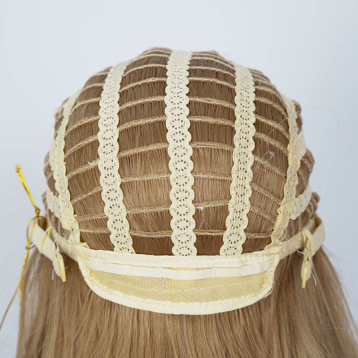 Warm-toned blonde wig cap with breathable mesh and visible wefted tracks