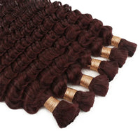 Curly hair bundle close-up in deep burgundy with gold bands along the weft