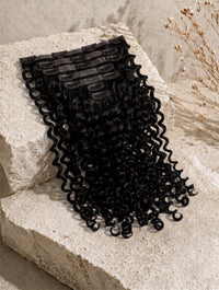 Seamless clip-in hair extensions weft with tight curly black hair and comb clips