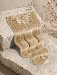 Seamless clip-in hair extensions in light blonde, body-wave style, with visible clips