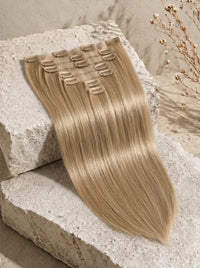 Seamless clip-in hair extensions in light blonde body wave with multiple metal clips