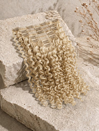 Clip-in hair extensions with light-blonde curly wefts and visible clips
