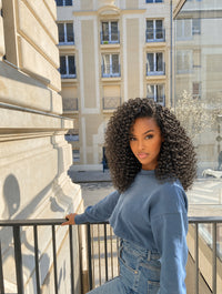 Clip-in extensions with curly texture, dark hair volume reaching to the shoulders