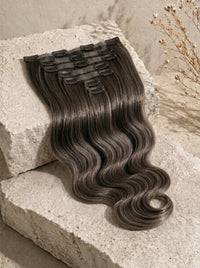 Clip-in hair extension weft in dark brown body wave with visible snap clips