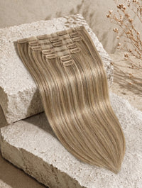 Seamless clip-in hair extensions with ash blonde straight hair and visible snap clips