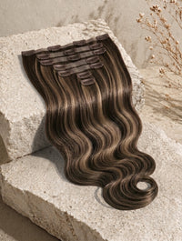 Clip-in hair extensions weft with wavy dark-brown hair and lighter highlights