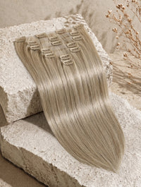 Seamless clip-in hair extension weft, ash-blonde straight strands with visible clips
