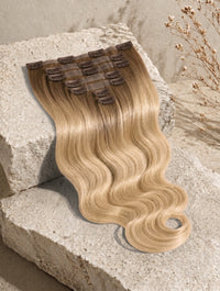 Seamless clip-in hair extensions in honey blonde, long wavy weft with clip backing