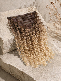 Seamless clip-in hair extensions in dark blonde, curly long weft with clip backing