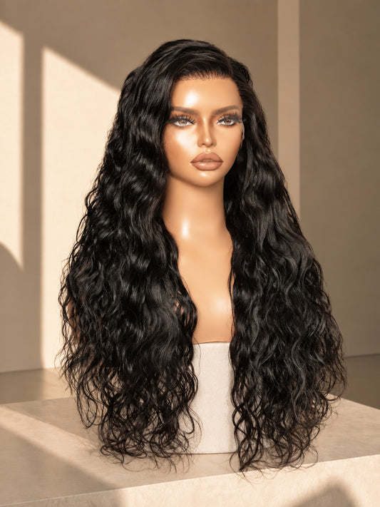 Long black curly lace wig with deep part and full volume, styled as loose waves