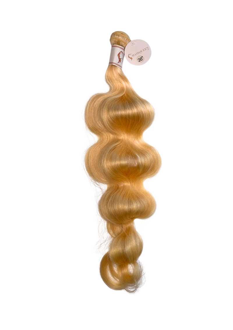 Hair bundle with loose body wave, long honey-blonde strands on weft.
