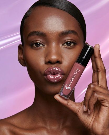 Lip kit plum lip gloss held near lips, glossy finish in a small bottle