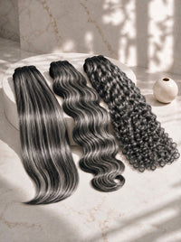 Assorted dark brown hair bundles: straight, wavy, and curly pieces arranged together.
