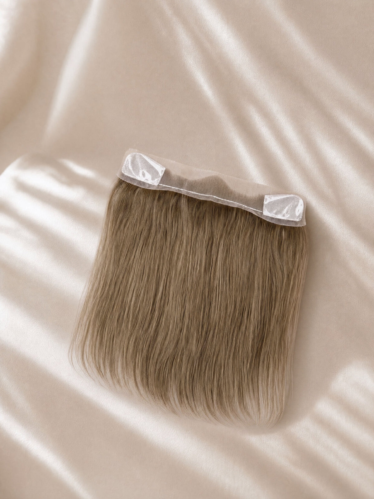 Lace hairline topper close-up with straight medium-brown hair and clear top tabs