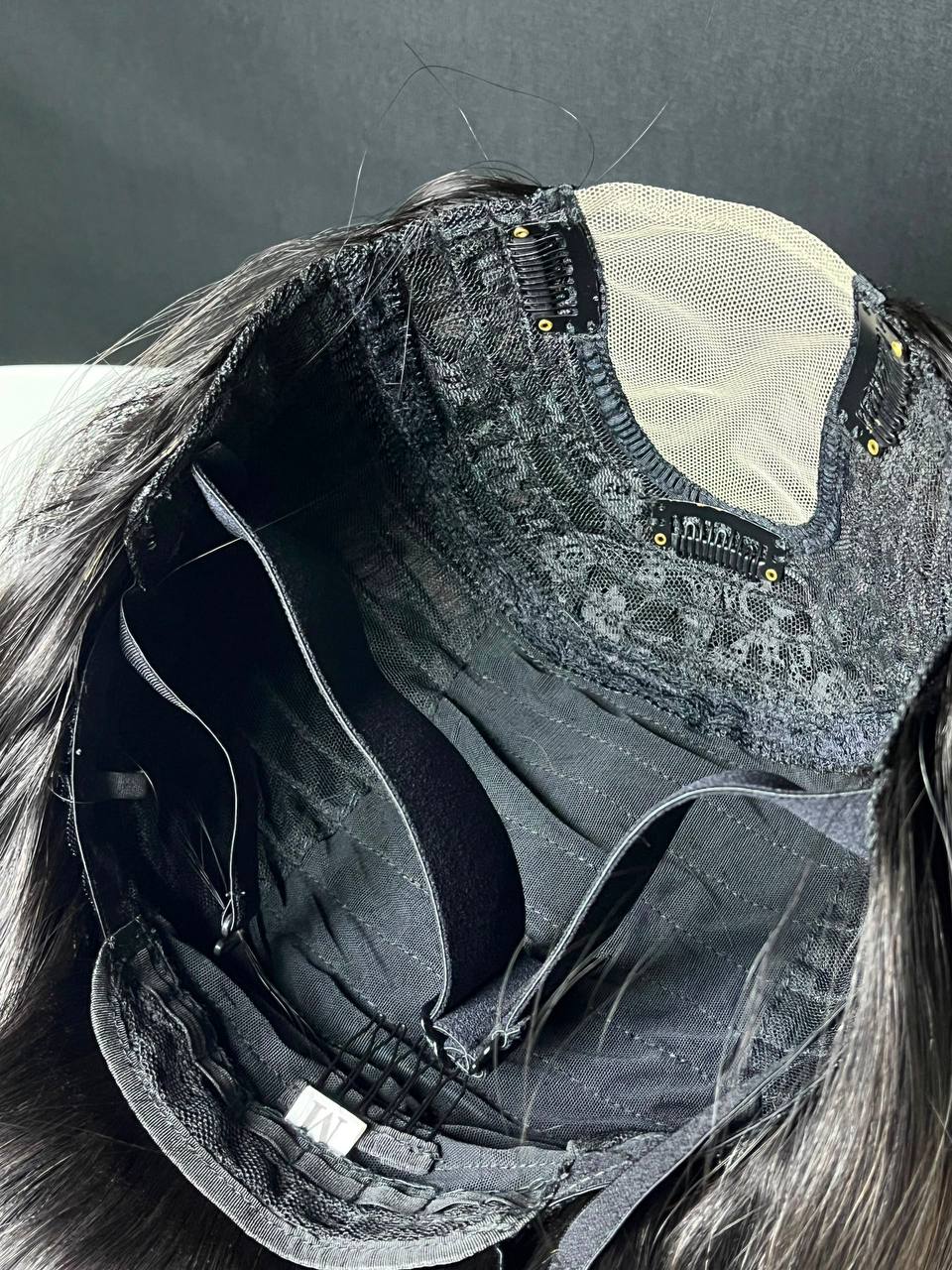 Dark U-part wig with adjustable straps and beige mesh cap, shown from inside