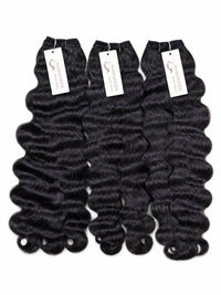 Black loose-wave human hair bundles, 3 pieces with white brand tags.
