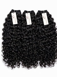 Black curly human hair bundles, 4 pieces with white brand tags.