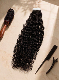 Curly tape-in hair extension in deep black, with tape tabs and matching clips