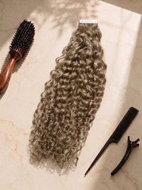 Curly tape-in hair extension in light blonde, with tape tabs and matching clips