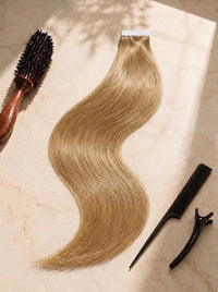 Straight tape-in extensions, warm blonde hair strand with tape tabs and styling clips
