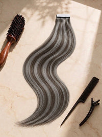 Straight tape-in hair weft, cool smoky silver-gray tones, wavy texture along length.