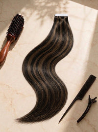 Tape-in hair extensions in black with dark brown tones, long wavy weft with tape top edge