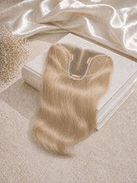 Hair topper extension in light blonde, wavy hair with U-shaped attachment clips.