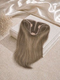 Light blonde hair topper with U-shaped base and clips on a satin cloth