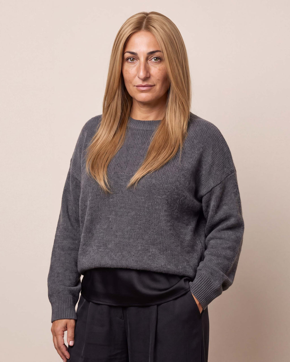 Gray crew-neck knit top with dark mono cover topper and a tied waist detail