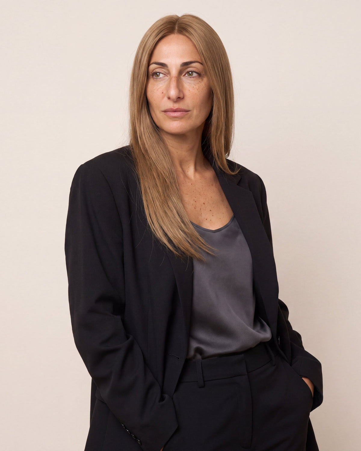 Model wearing a long straight blonde hair topper, side-swept style.