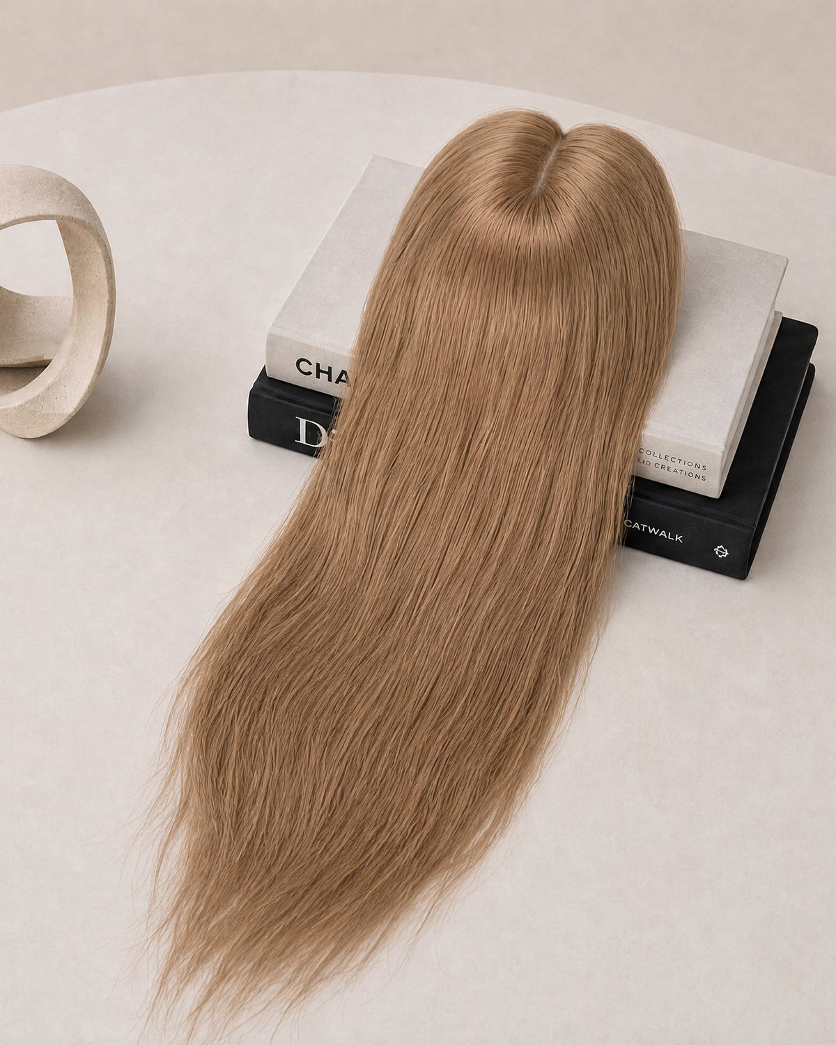 Light blonde hair topper with lace base and long straight strands, top view.