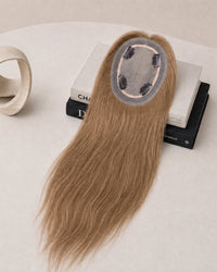 Light blonde hair topper with oval lace base and attached clips, top view.