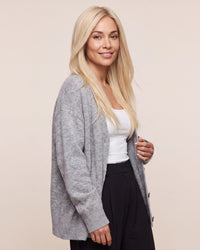 Silicone skin topper with straight light blonde hair, side-swept part.