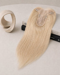 Warm blonde hair topper with clear base and three fastening clips