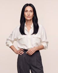 Hairline topper worn under a white blouse; dark straight hair with natural-looking part
