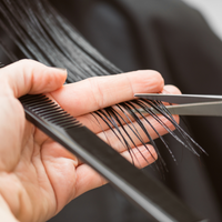 Hair cutting class grooming: hands combing hair with a black comb