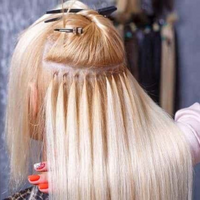 Blonde micro loop hair extensions with stitched weft and metal clips, close-up